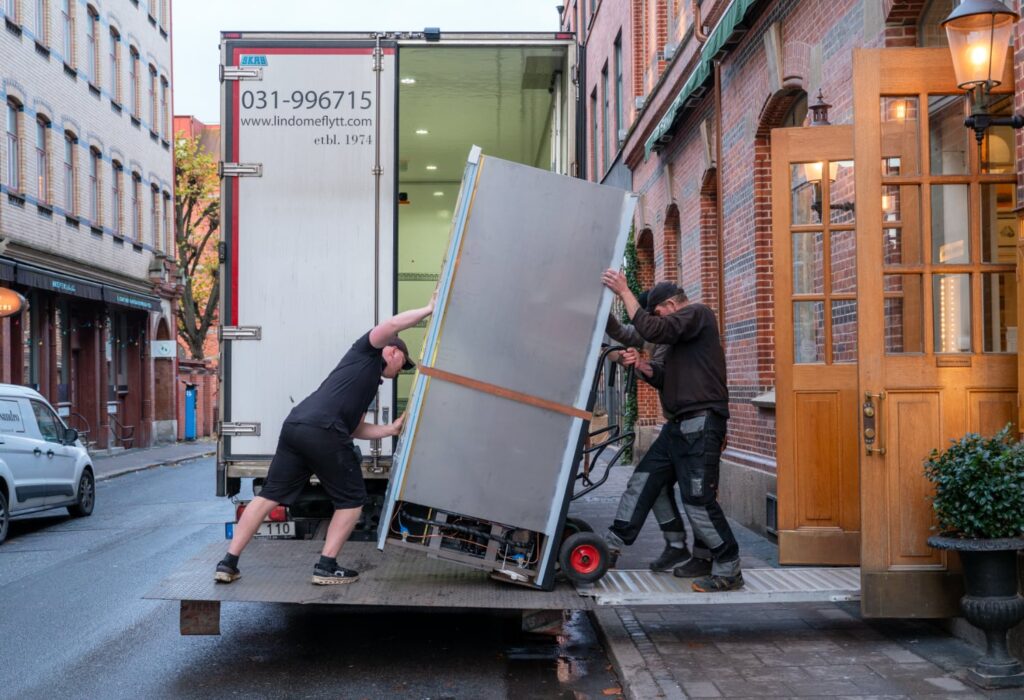 tunghantering-goteborg Två flyttkillar som lyfter en tung maskin i samband med flytt
